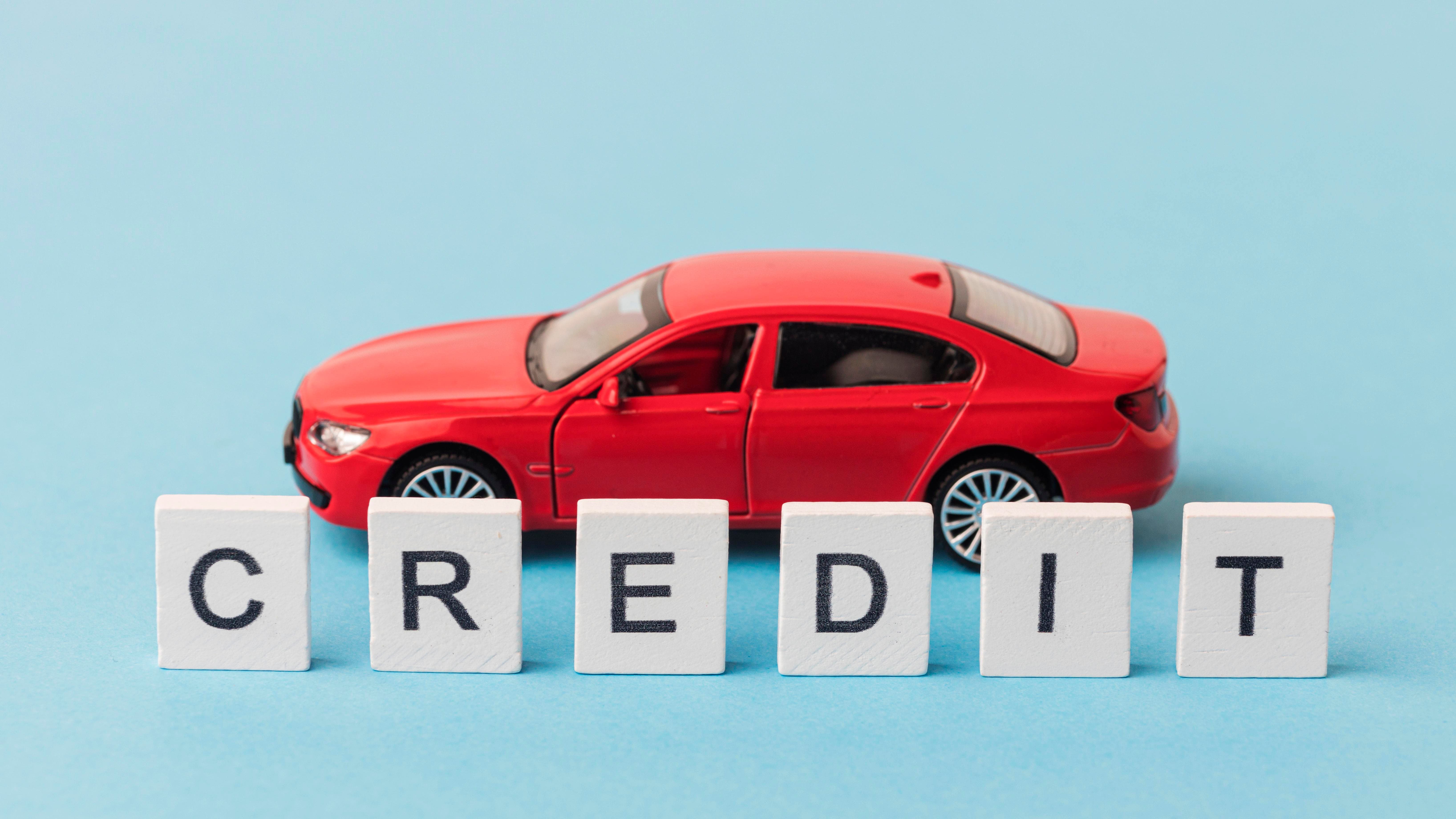 mot-de-credit-a-cote-d-une-voiture-rouge